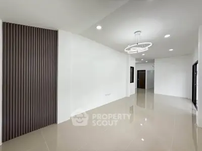 Spacious modern living room with sleek lighting and glossy tiled floors
