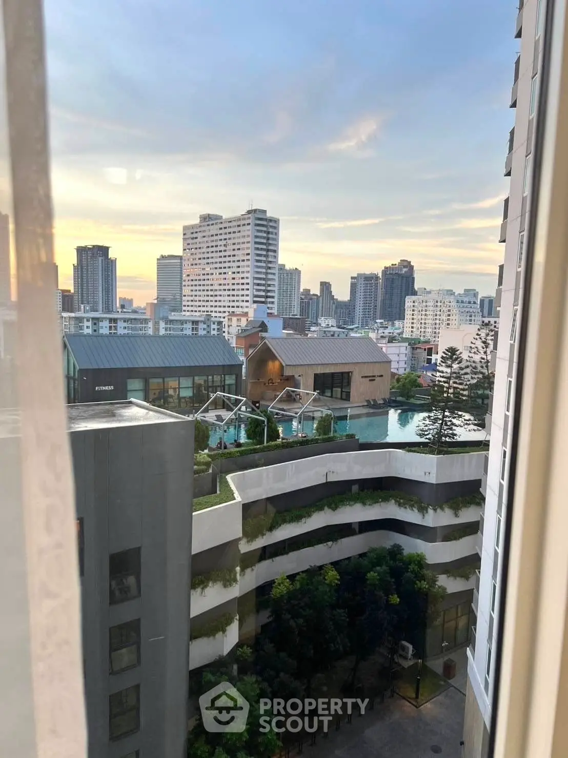 Stunning cityscape view from high-rise apartment window at sunset
