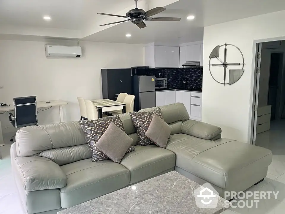 Modern living room with sleek furniture and open kitchen layout in a stylish apartment.