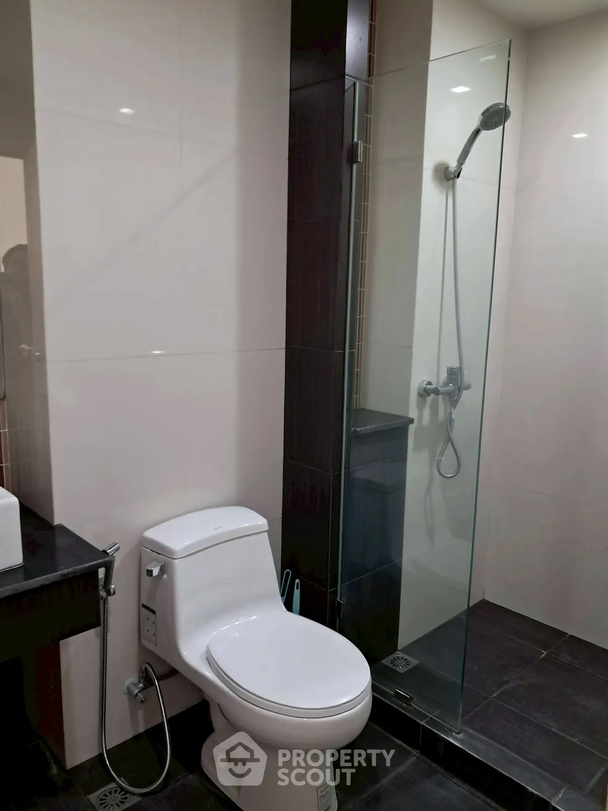 Modern bathroom with glass shower and sleek fixtures in contemporary apartment.