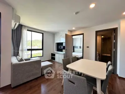 Modern living room with dining area and natural light in stylish apartment.