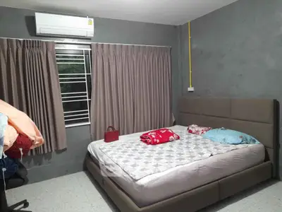Cozy bedroom with modern decor and air conditioning, featuring a comfortable bed and stylish curtains.