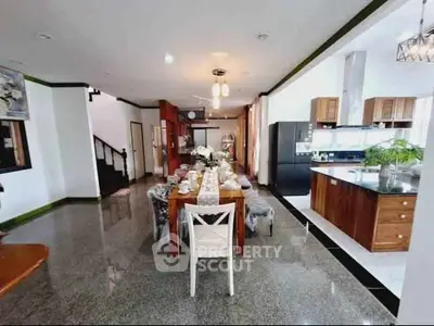 Spacious dining area with elegant table setting and modern kitchen in open layout
