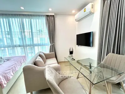 Modern living room with glass table and cozy seating in bright apartment