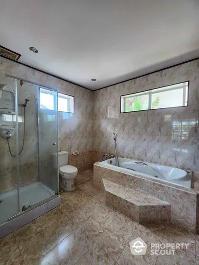 Spacious bathroom with luxurious bathtub and modern shower enclosure