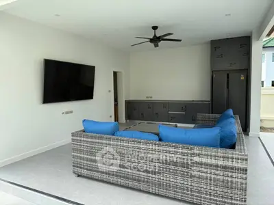 Modern outdoor living area with sleek furniture and wall-mounted TV