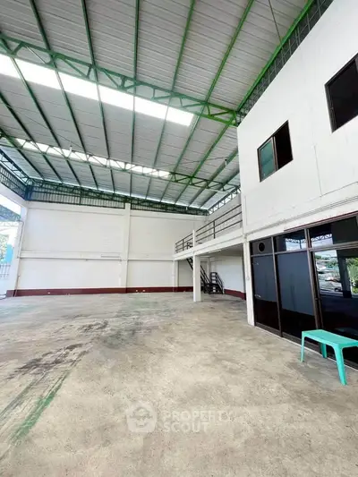 Spacious industrial warehouse with high ceilings and ample natural light, perfect for storage or manufacturing.