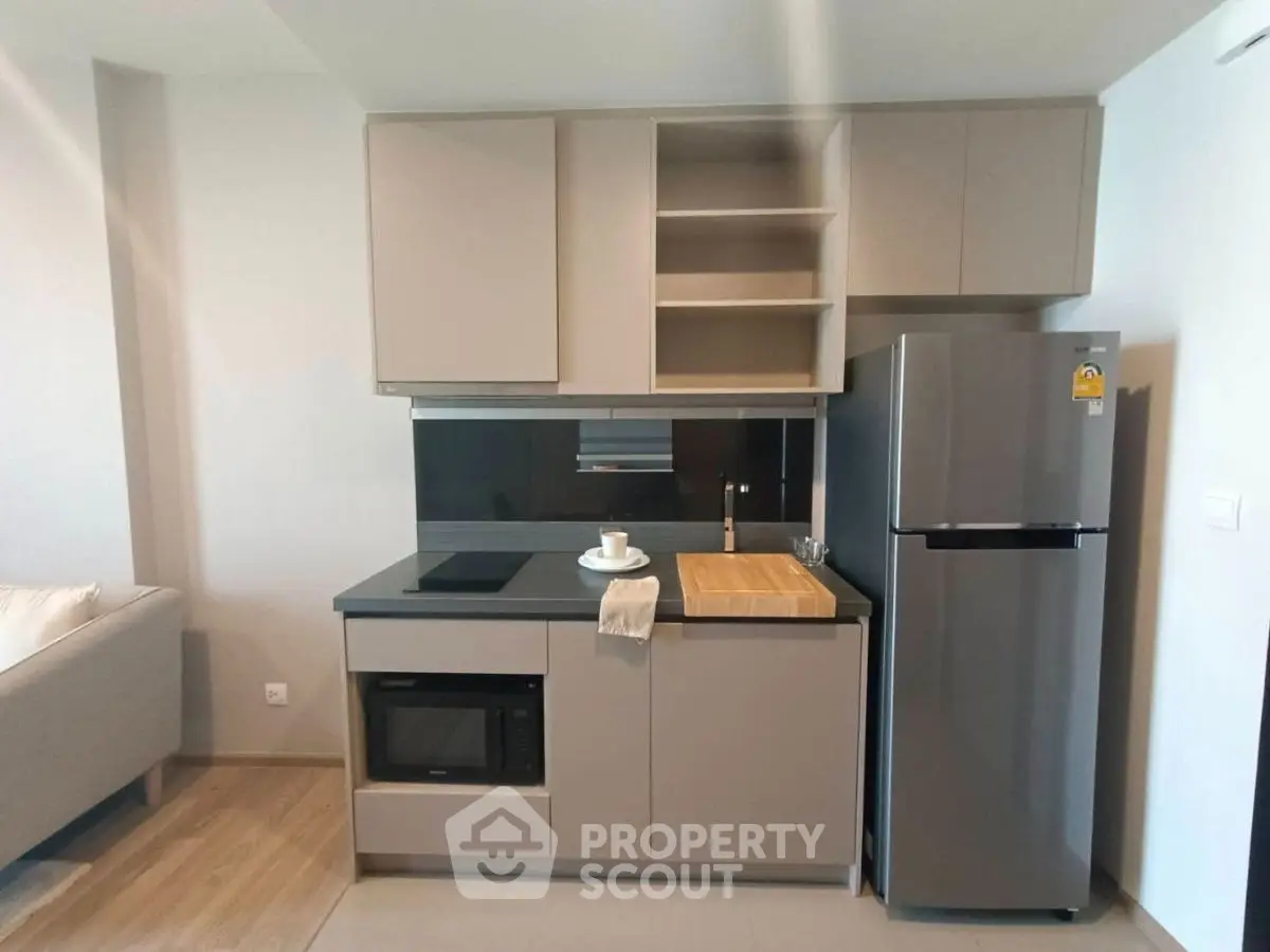 Modern compact kitchen with sleek cabinets and stainless steel fridge