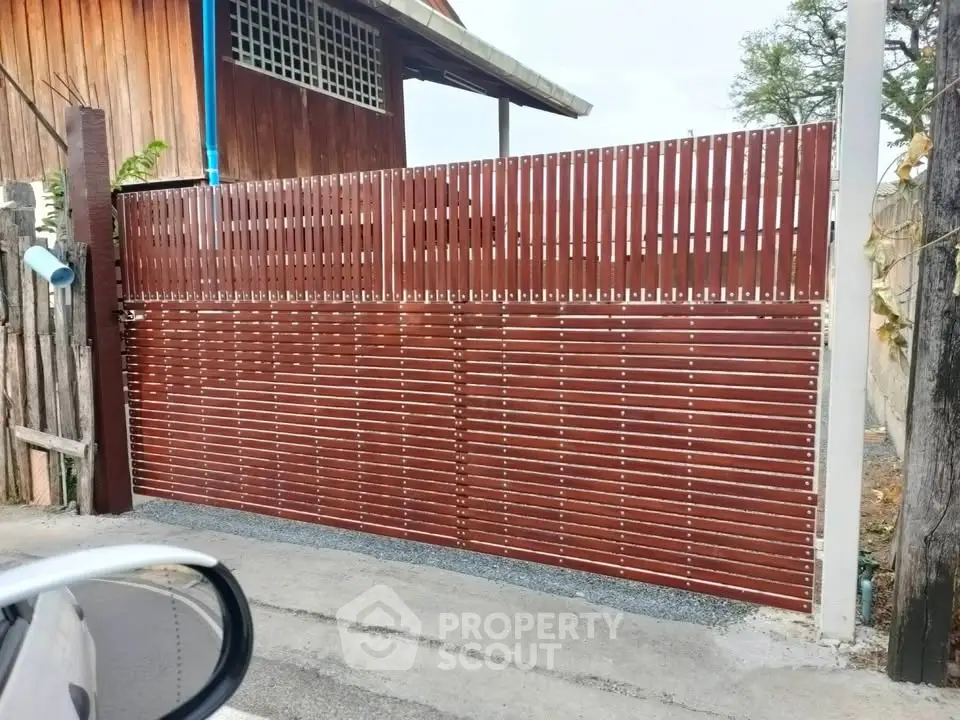 Stylish wooden gate with modern design in residential area, enhancing curb appeal and security.