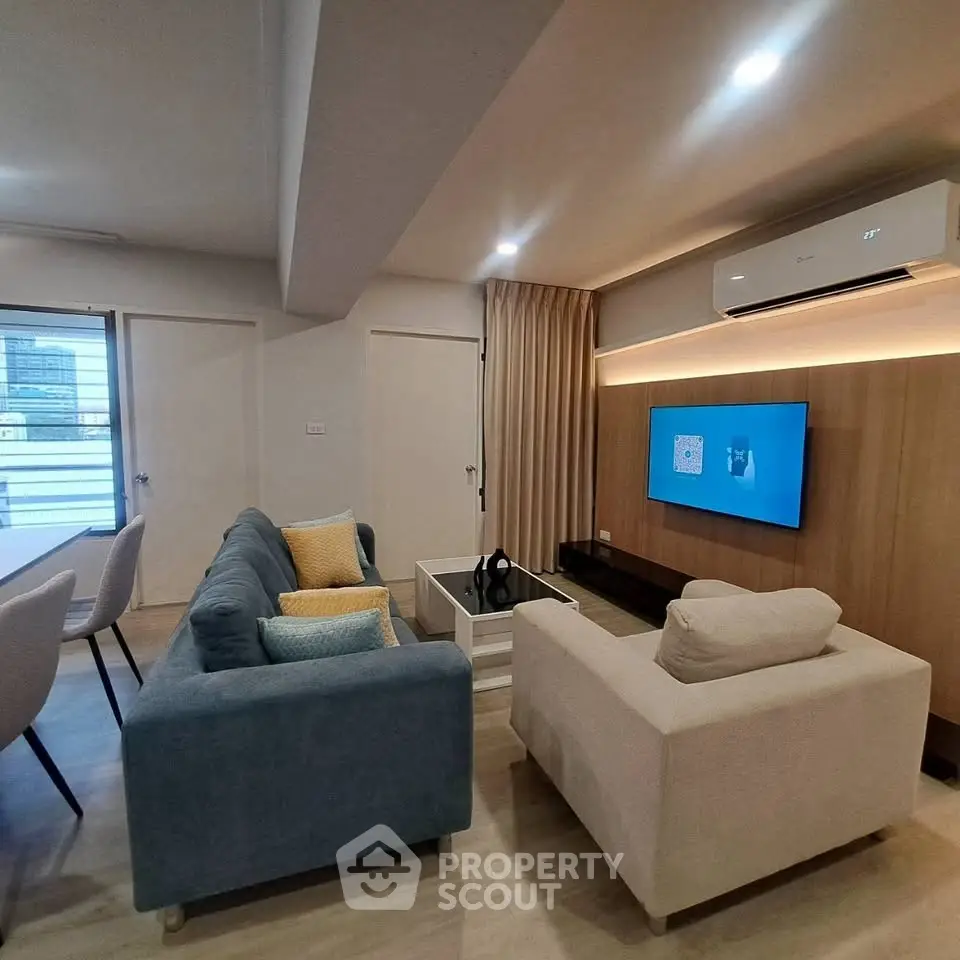 Modern living room with stylish furniture and wall-mounted TV