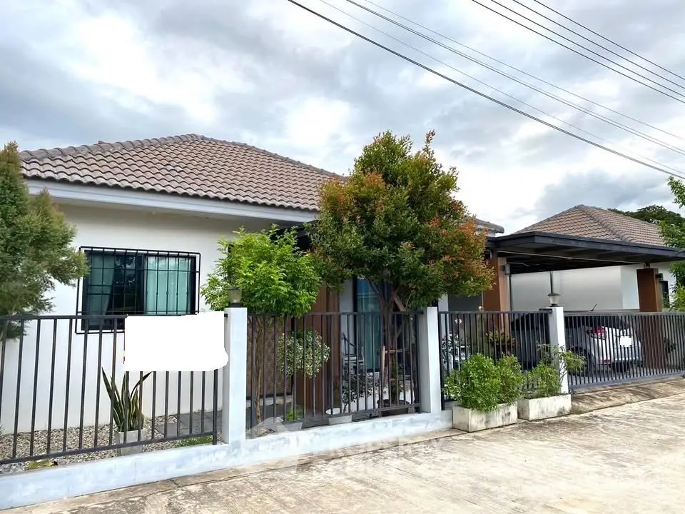 Charming single-story house with lush garden and secure gated entrance.