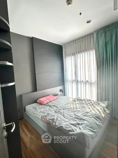 Modern bedroom with natural light and stylish decor in a contemporary apartment.