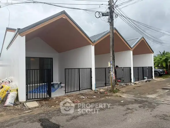 Modern row of newly built houses with sleek design and gated entrances.
