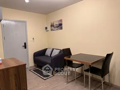 Cozy living room with modern sofa and dining table, perfect for small apartments.