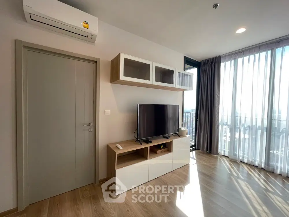 Modern living room with TV unit and large window offering city views