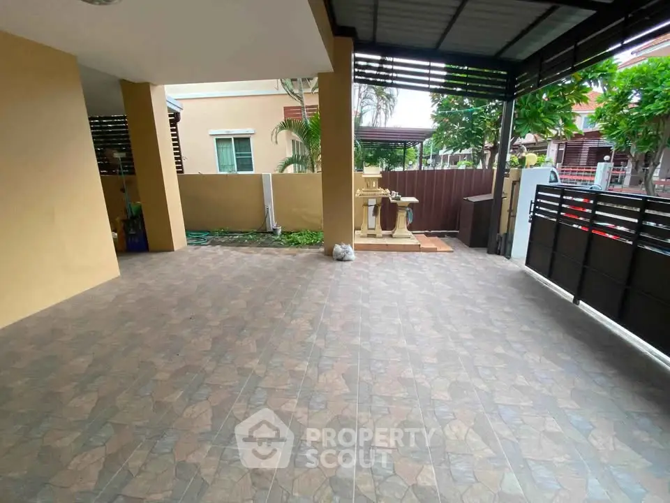 Spacious covered patio with tiled flooring and garden view in modern home.