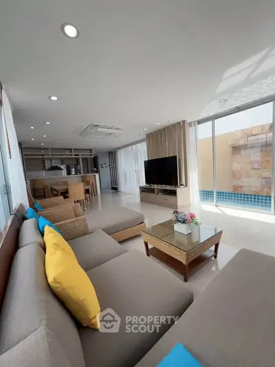 Spacious modern living room with pool view, open kitchen, and stylish decor.