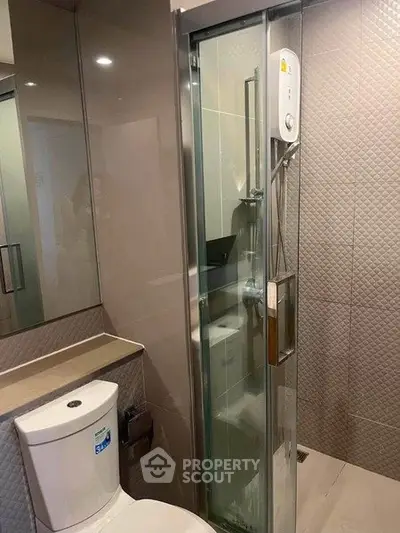 Modern bathroom with sleek shower and toilet in contemporary design.