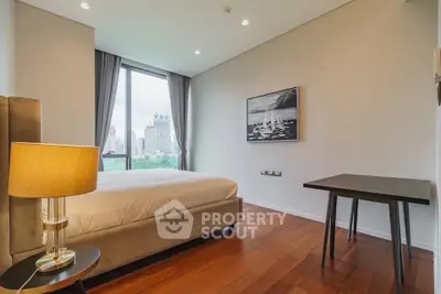 Modern bedroom with city view, featuring elegant decor and large window for natural light.
