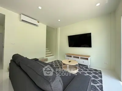 Modern living room with sleek furniture and wall-mounted TV, perfect for relaxation and entertainment.