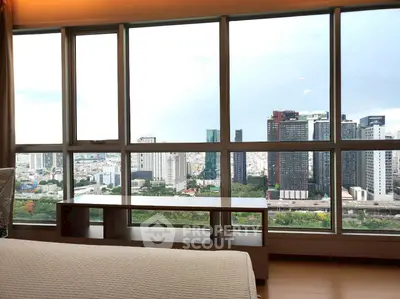 Stunning cityscape view from a modern high-rise apartment bedroom window.