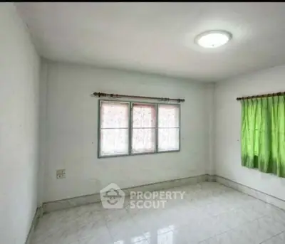 Spacious empty room with tiled floor and natural light from windows