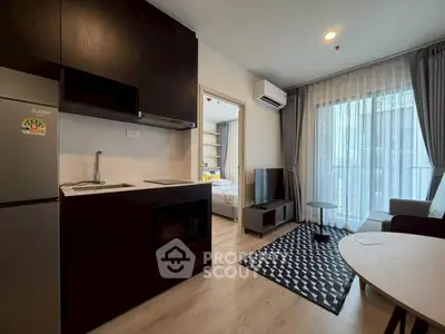 Modern open-plan living room with sleek kitchen and cozy bedroom view.