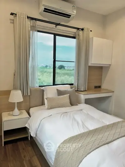 Cozy bedroom with a scenic view, featuring a comfortable bed and modern decor.