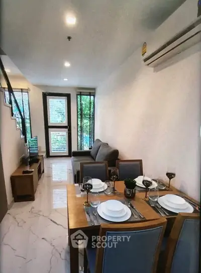 Modern living room with dining area and staircase in stylish apartment