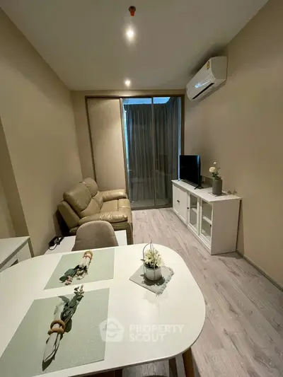 Modern living room with cozy seating and sleek entertainment unit in a stylish apartment.