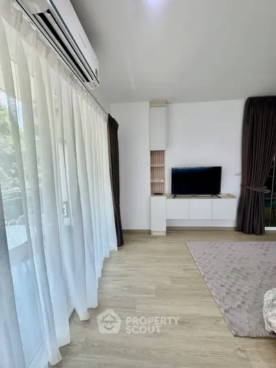 Modern living room with large windows and stylish TV setup