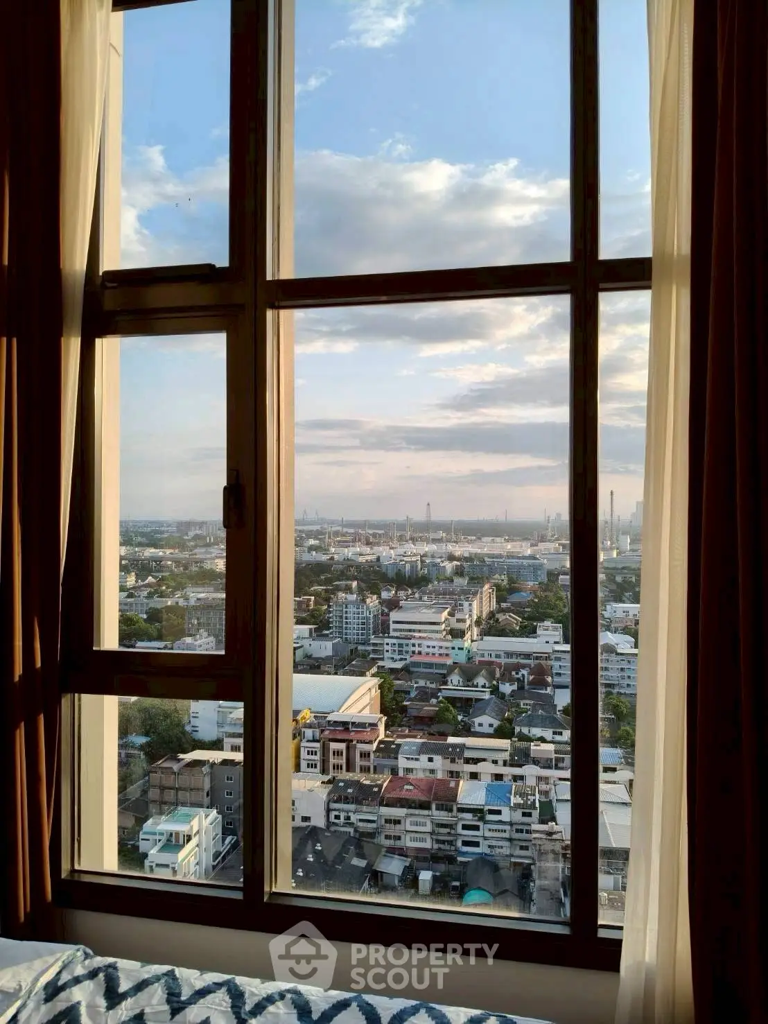Stunning cityscape view from a high-rise apartment window at sunset.