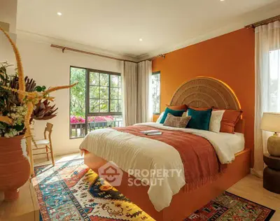 Luxurious bedroom with vibrant decor and large windows offering natural light and garden views.