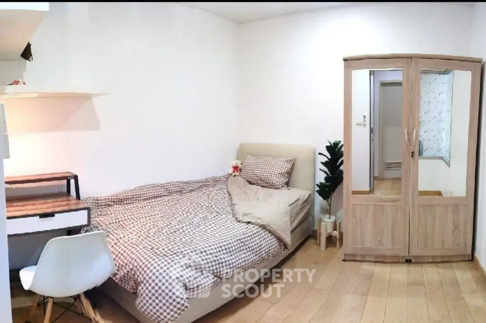 Cozy bedroom with modern furniture and wooden flooring, perfect for a comfortable living experience.