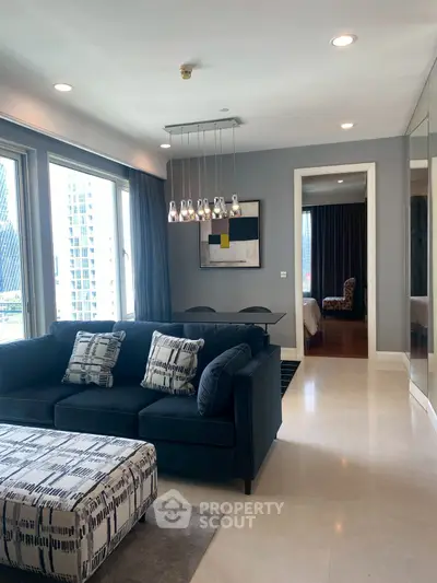 Modern living room with stylish decor and city view, featuring a chic sofa and elegant lighting.