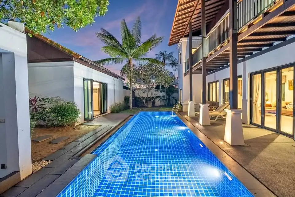 Luxurious villa with private pool and tropical garden at sunset, perfect for relaxation and entertainment.