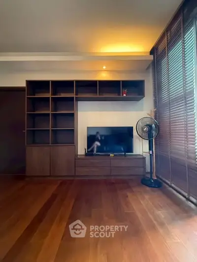 Spacious living room with wooden flooring and modern entertainment unit.