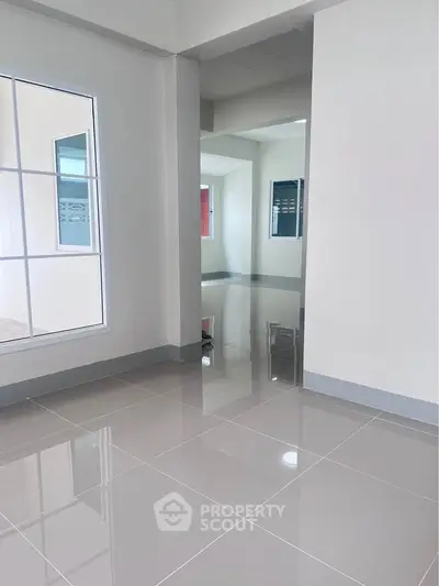 Spacious modern interior with glossy tiled floors and large windows