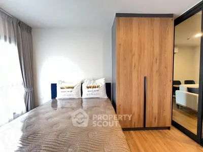 Modern bedroom with wooden wardrobe and cozy bedding in a stylish apartment.