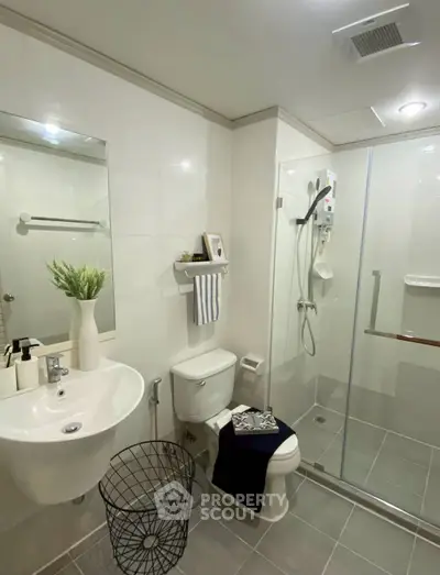 Modern bathroom with glass shower, sleek sink, and stylish decor