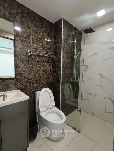 Luxurious modern bathroom with marble walls and glass shower enclosure