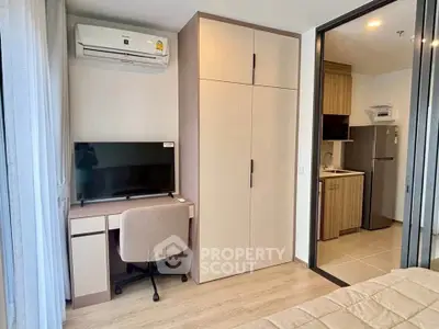 Modern bedroom with workspace and kitchenette in stylish apartment