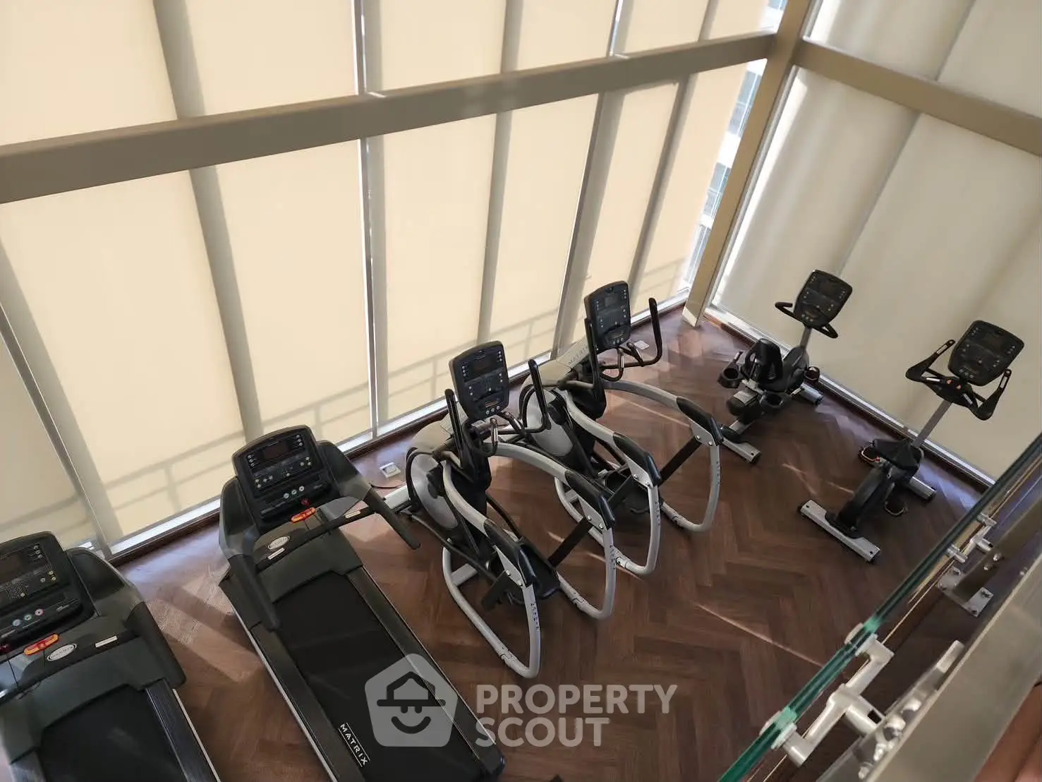 Modern gym with state-of-the-art exercise equipment and large windows for natural light.