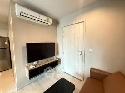 Modern living room with sleek furniture and wall-mounted TV in a cozy apartment.
