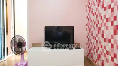 Charming living room with modern TV setup and stylish pink accent wall.