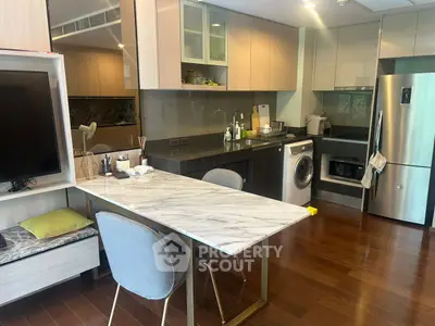 Modern kitchen with marble dining table, sleek appliances, and wooden flooring