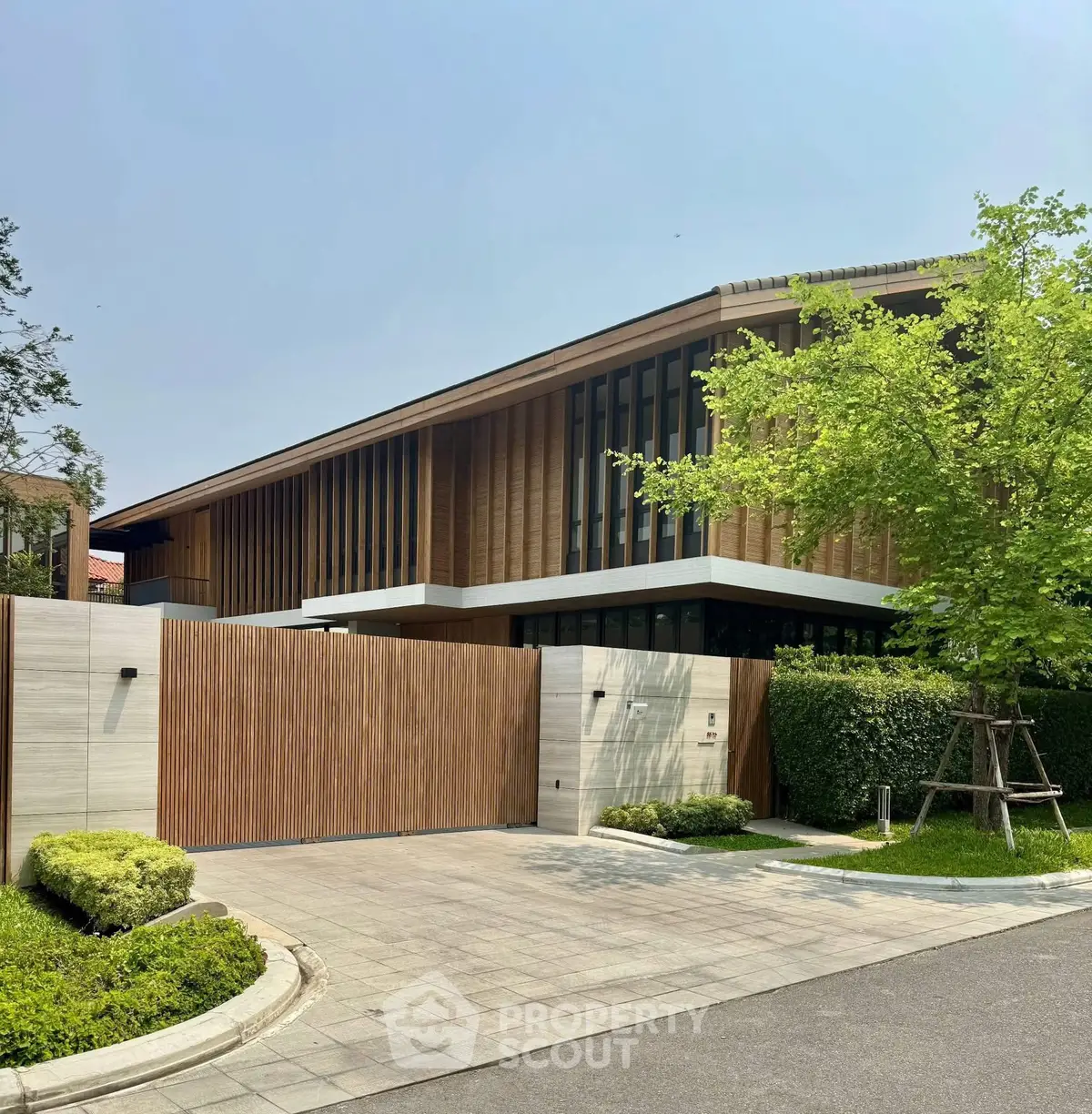 Modern luxury home with wooden facade and lush landscaping