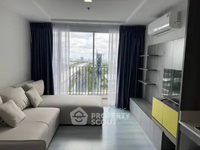 Modern living room with large window and city view, featuring comfortable sofa and sleek TV unit.