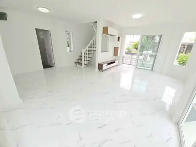Spacious modern living room with marble flooring and large windows for natural light.