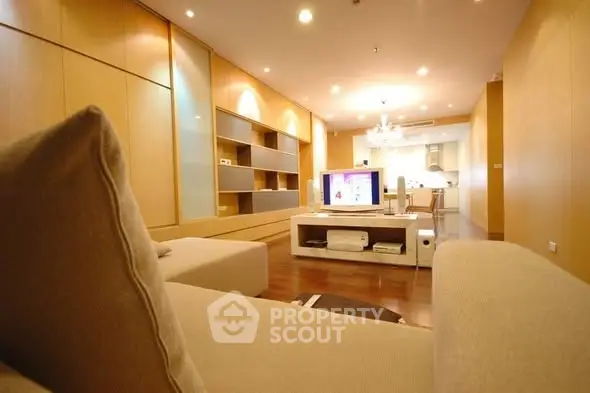 Spacious modern living room with open kitchen and elegant lighting.